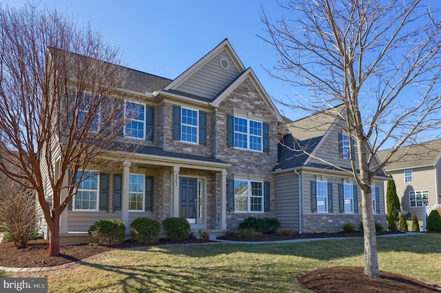 craftsman house featuring stone siding, a front yard, and roof with shingles