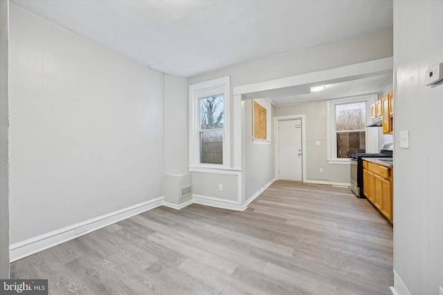 interior space featuring visible vents, light wood-style flooring, and baseboards