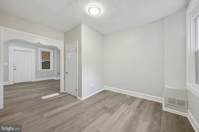 empty room featuring visible vents, baseboards, and wood finished floors