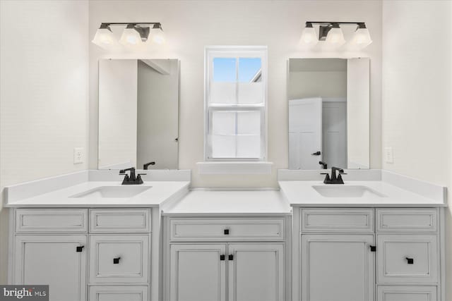 full bathroom with a sink and double vanity