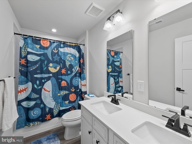 full bathroom featuring a sink, visible vents, toilet, and wood finished floors