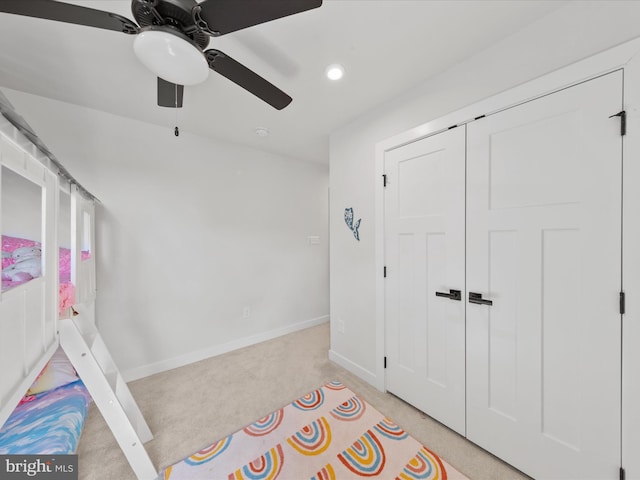 unfurnished bedroom with baseboards, recessed lighting, ceiling fan, a closet, and light carpet