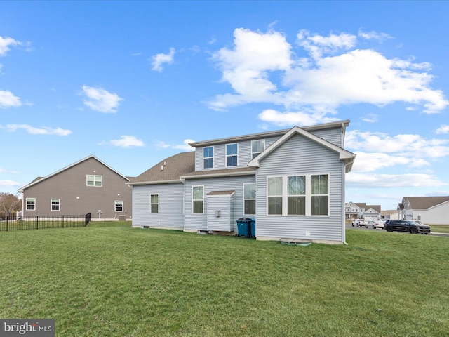 rear view of property with a lawn and fence