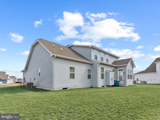 back of property featuring central air condition unit, a shingled roof, and a yard