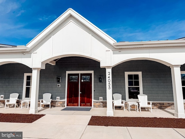 entrance to property featuring covered porch and stone siding