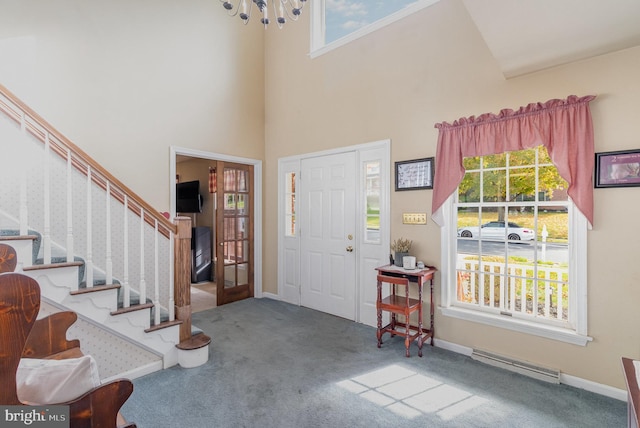 entrance foyer featuring visible vents, carpet flooring, plenty of natural light, and stairway