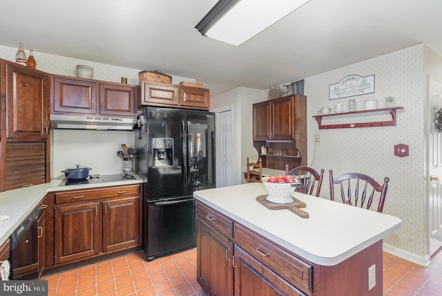 kitchen with black appliances, wallpapered walls, under cabinet range hood, and light countertops