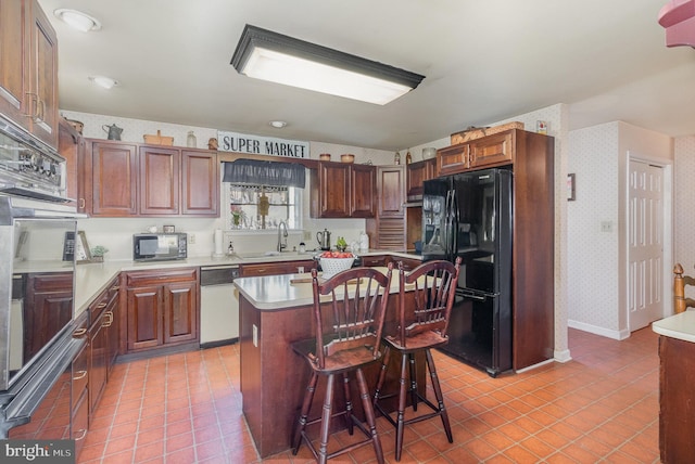 kitchen featuring black appliances, a sink, light countertops, and wallpapered walls