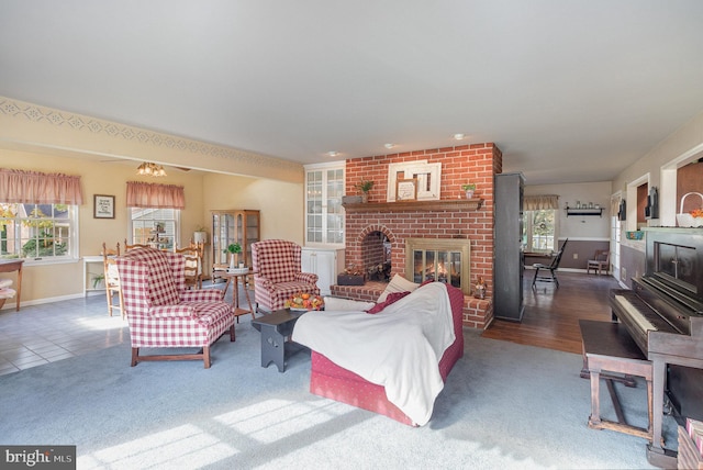 carpeted living area featuring a brick fireplace, tile patterned flooring, and baseboards