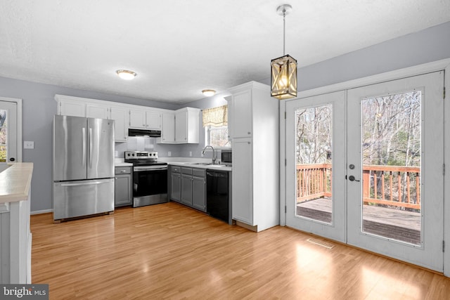 kitchen featuring under cabinet range hood, plenty of natural light, appliances with stainless steel finishes, and a sink