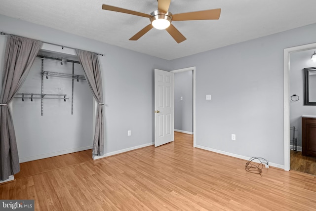 unfurnished bedroom with ceiling fan, wood finished floors, a closet, and baseboards