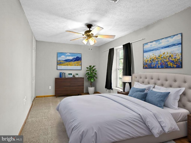 bedroom with baseboards, carpet flooring, a textured ceiling, and ceiling fan