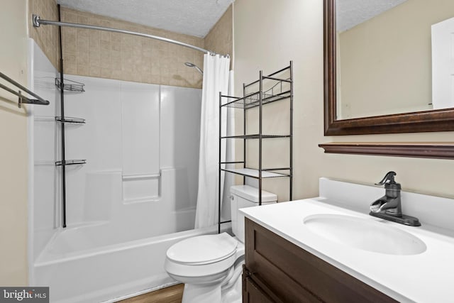 bathroom with vanity, shower / bath combination with curtain, toilet, and a textured ceiling