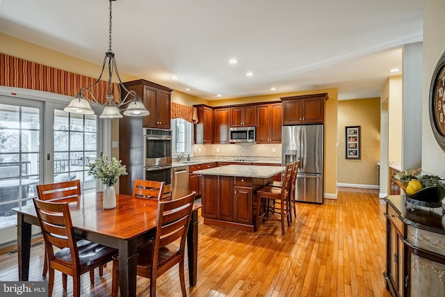 dining area featuring recessed lighting, baseboards, and light wood-style floors