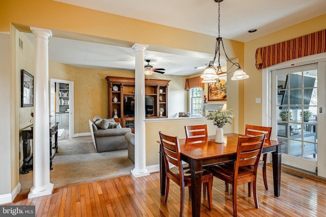 dining room with light wood finished floors, visible vents, ornate columns, and ceiling fan