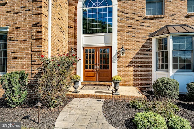 property entrance featuring french doors and brick siding