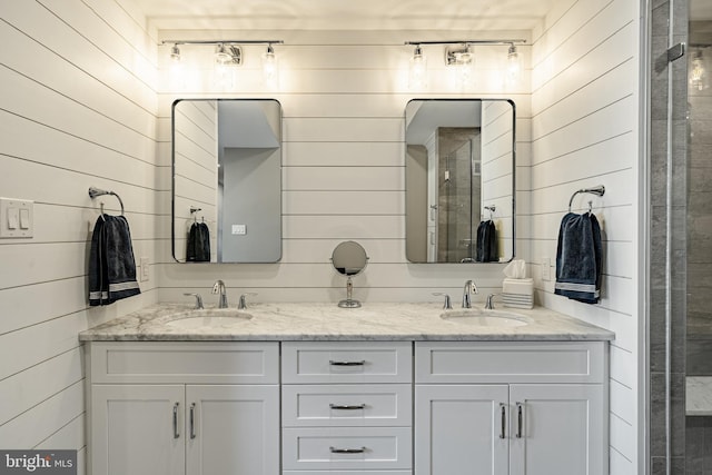 bathroom with double vanity, wood walls, and a sink