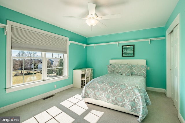 carpeted bedroom with a closet, visible vents, ceiling fan, and baseboards