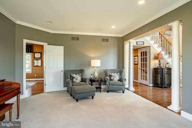 living area featuring visible vents, ornate columns, and ornamental molding