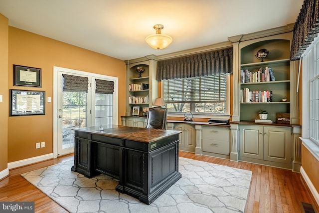 office with light wood-style floors, visible vents, a wealth of natural light, and baseboards