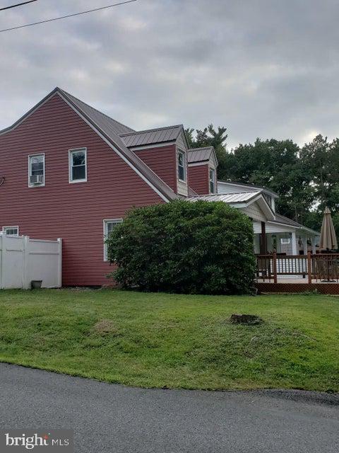 view of home's exterior featuring a yard, metal roof, and fence