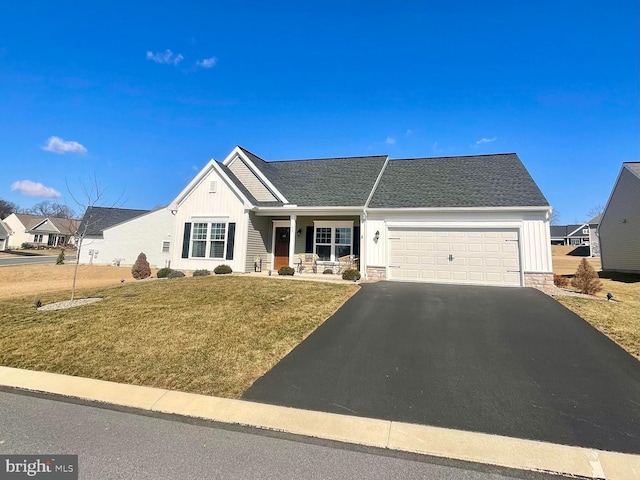 ranch-style home featuring a garage, board and batten siding, driveway, and a front lawn