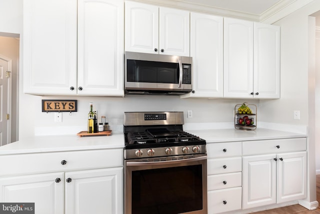 kitchen featuring white cabinetry, stainless steel appliances, and light countertops