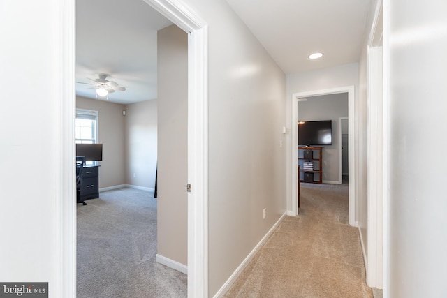 hall with recessed lighting, light colored carpet, and baseboards