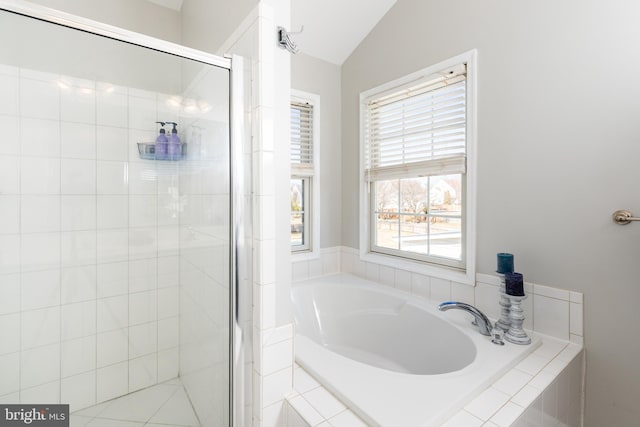 bathroom with a stall shower, lofted ceiling, and a garden tub