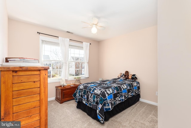 carpeted bedroom with visible vents, a ceiling fan, and baseboards