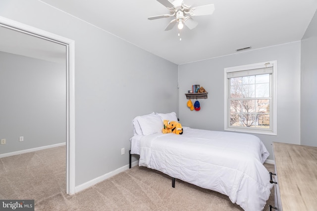 carpeted bedroom with visible vents, a ceiling fan, and baseboards