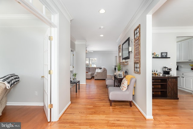 hallway with light wood-type flooring and crown molding