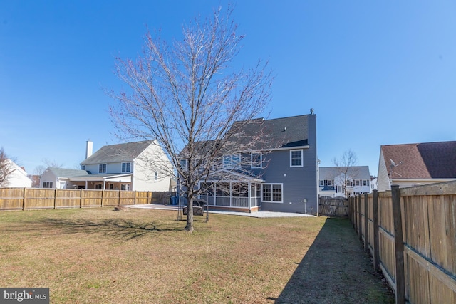 back of house featuring a yard, a patio, and a fenced backyard