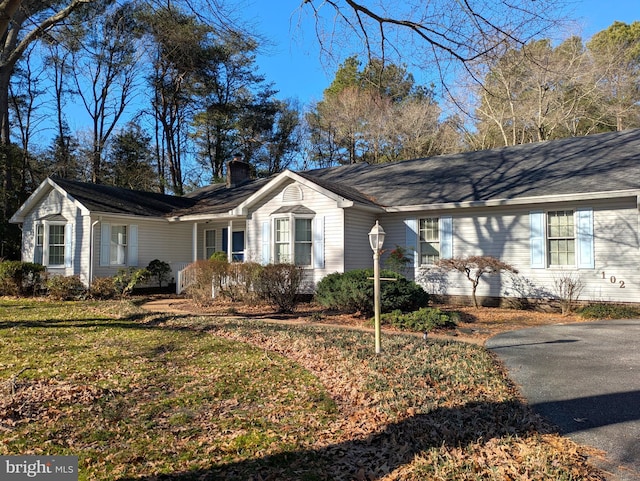 view of front of house with a front yard and a chimney