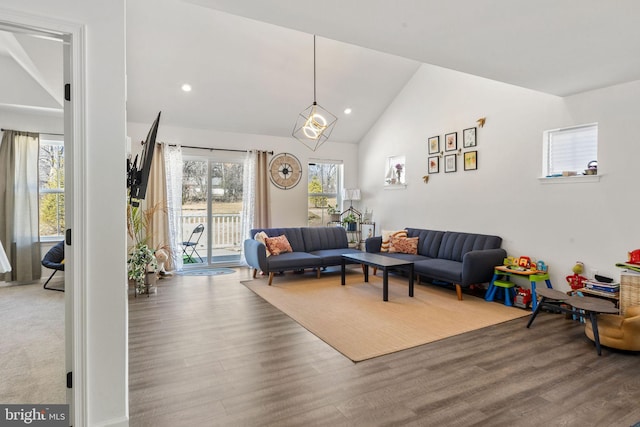 living area with recessed lighting, high vaulted ceiling, and wood finished floors