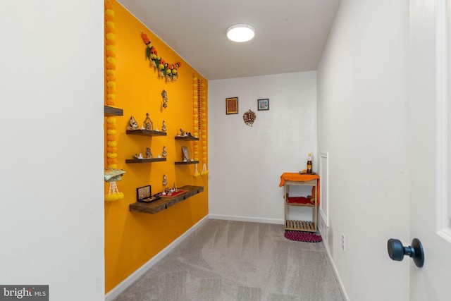 hallway featuring baseboards and carpet