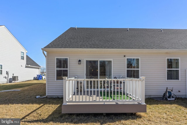 back of property featuring a wooden deck, central AC unit, a lawn, and roof with shingles