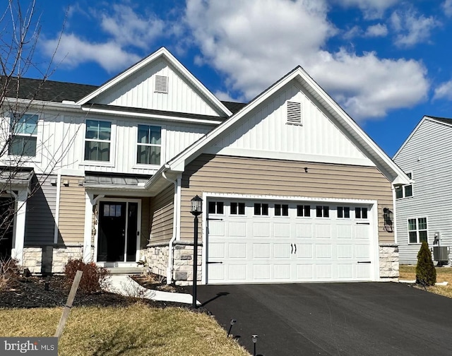 view of front of house featuring stone siding, board and batten siding, and driveway