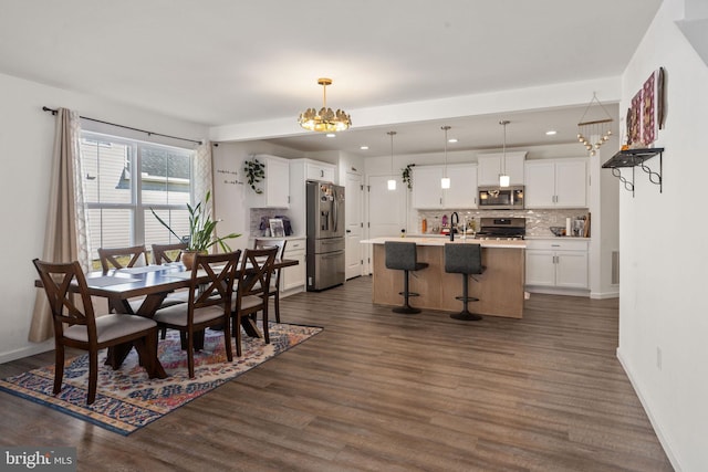 dining area with recessed lighting, baseboards, dark wood-type flooring, and a notable chandelier