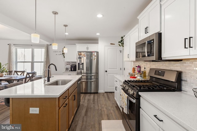 kitchen with dark wood-type flooring, backsplash, appliances with stainless steel finishes, and a sink