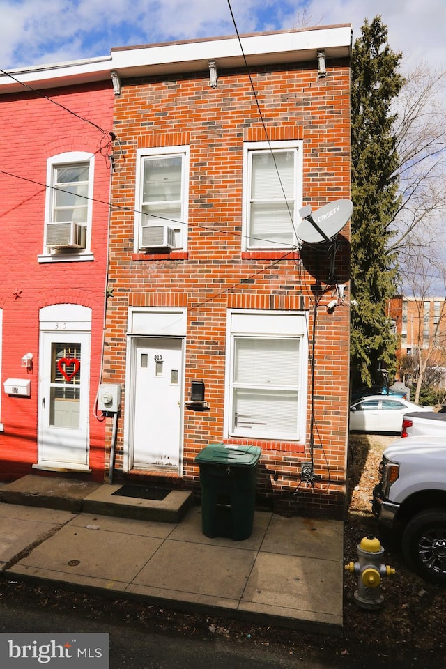 view of property with brick siding and cooling unit