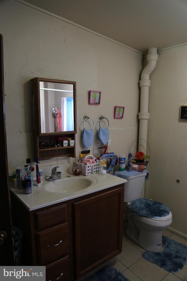 bathroom featuring toilet, vanity, and tile patterned flooring