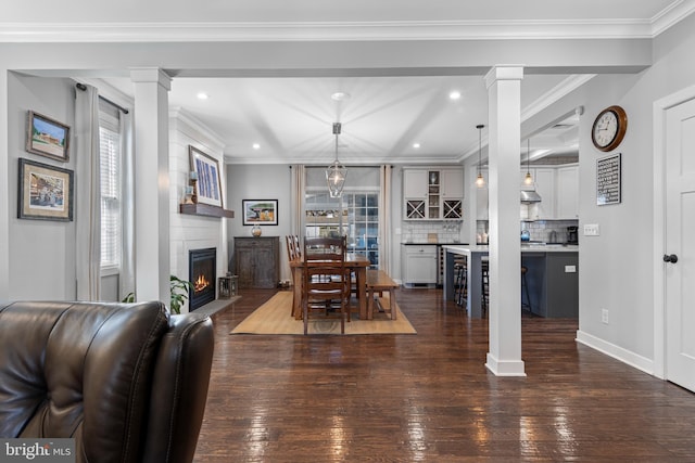 631 Monument Ave, Malvern, PA 19355 - dining area featuring ornamental molding, dark wood-style floors, recessed lighting, a large fireplace, and ornate columns