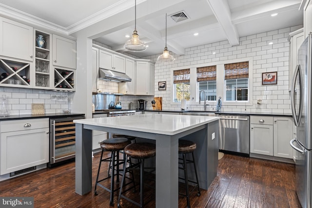 631 Monument Ave, Malvern, PA 19355 - kitchen with a kitchen bar, dark wood-type flooring, beverage cooler, under cabinet range hood, and appliances with stainless steel finishes