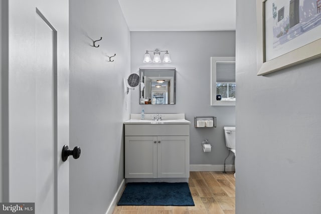 631 Monument Ave, Malvern, PA 19355 - half bathroom featuring baseboards, toilet, wood finished floors, and vanity