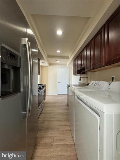 laundry area with baseboards, light wood finished floors, laundry area, recessed lighting, and independent washer and dryer