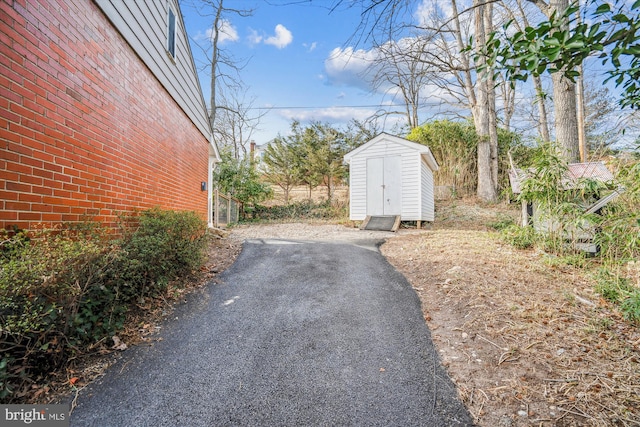 exterior space featuring an outbuilding, a shed, and driveway