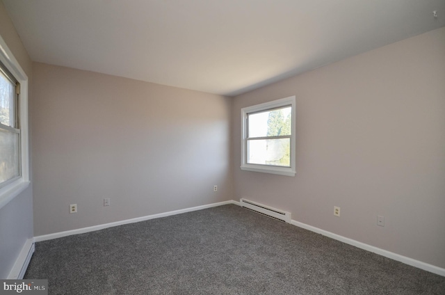 unfurnished room with baseboards, a baseboard heating unit, and dark carpet