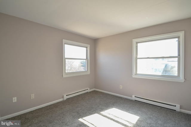 unfurnished room featuring a baseboard heating unit, carpet floors, and baseboards