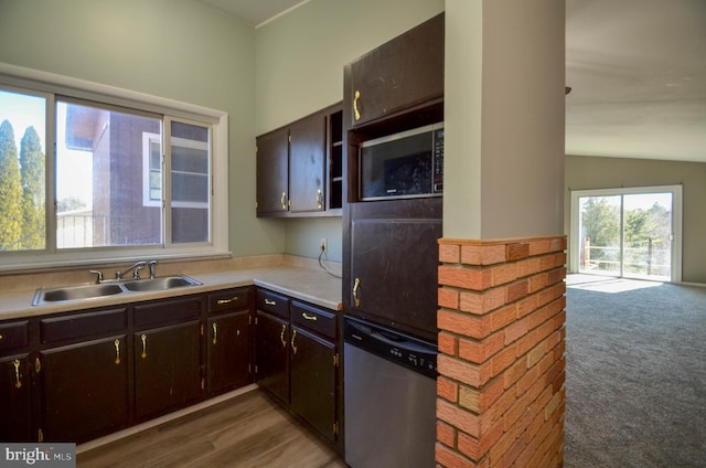 kitchen featuring a sink, vaulted ceiling, light countertops, stainless steel dishwasher, and dark brown cabinets